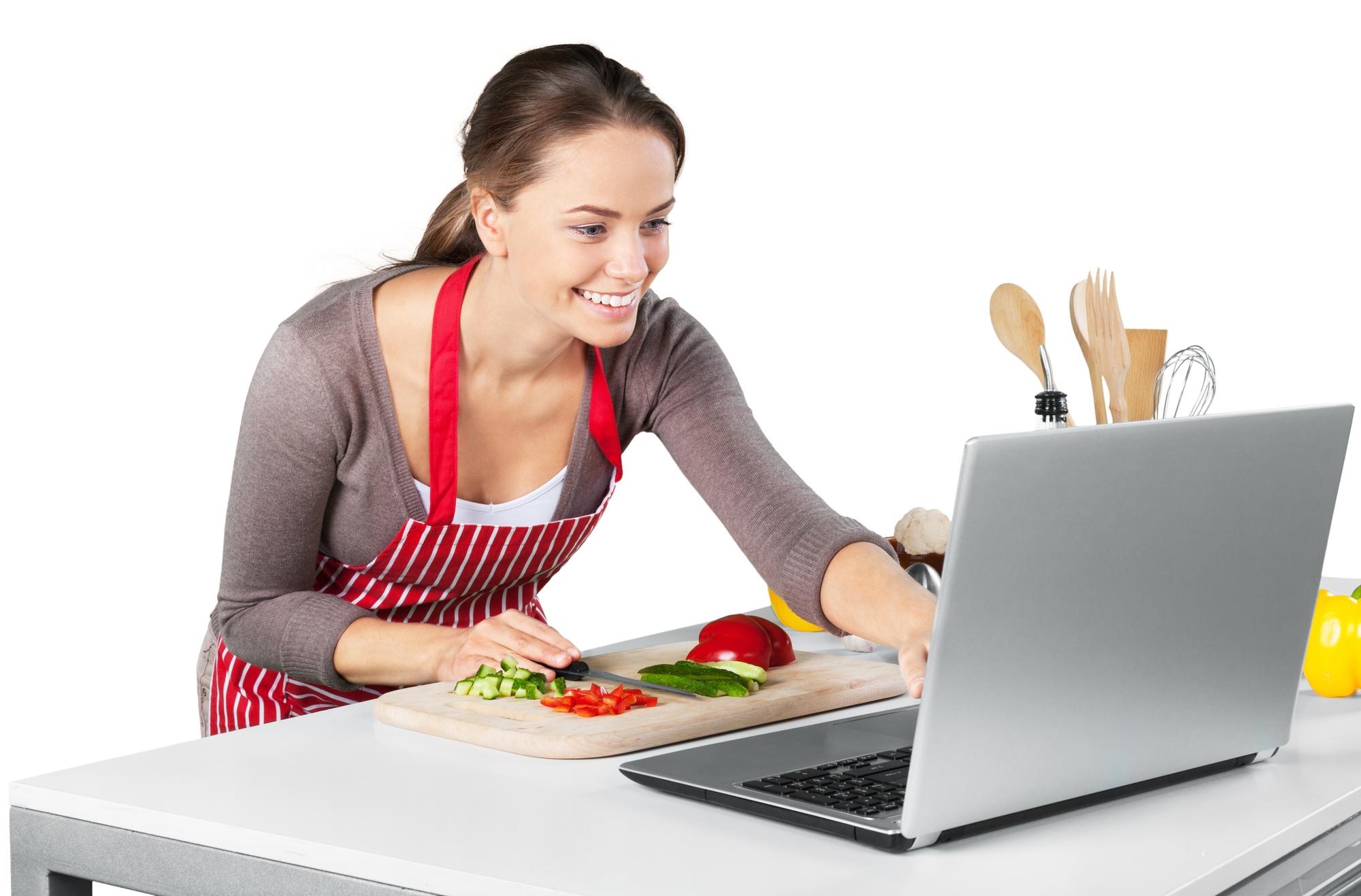 Estudiante siguiendo tutorial en laptop en cocina hogareña